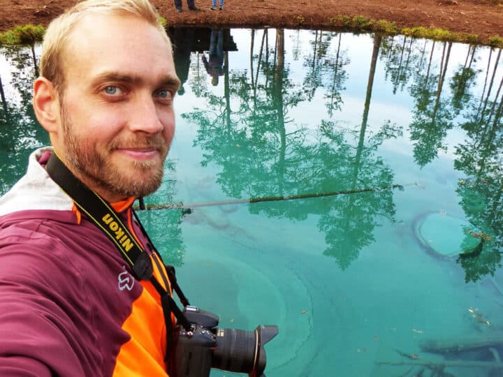 Bild på Jonathan med en kamera, vid en sjö